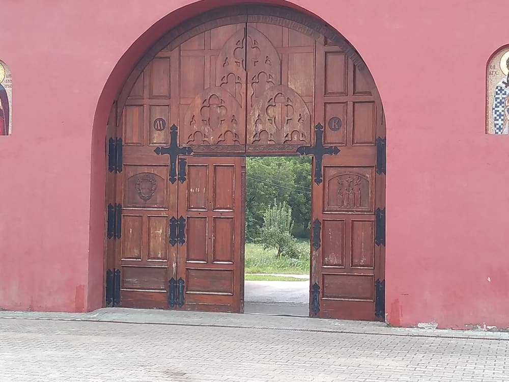 The carved wooden gate in the red outer wall of Krušedol Monastery